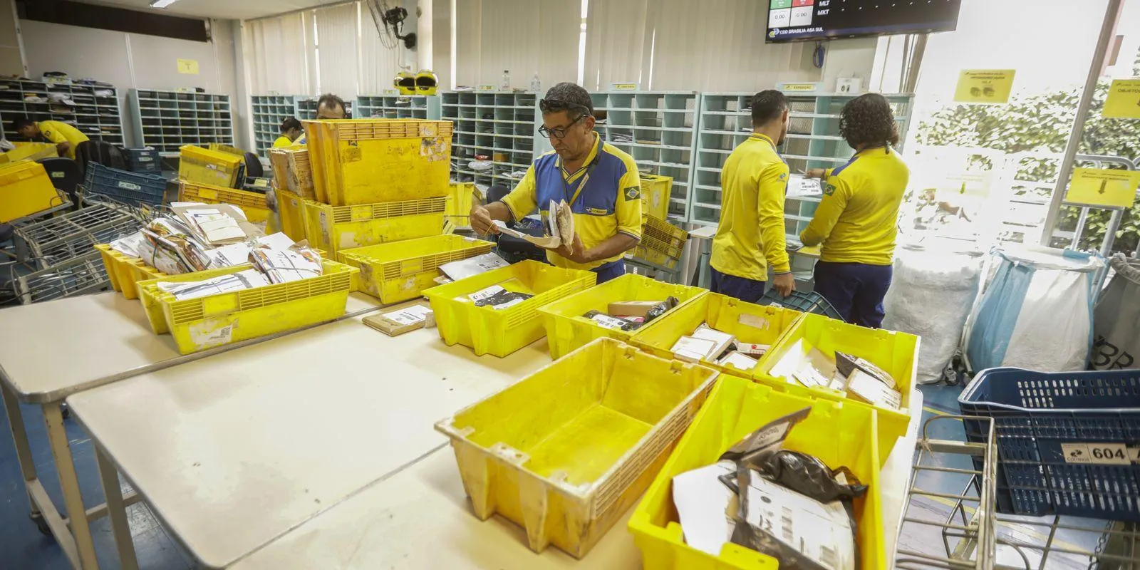 Carteiros trabalhando em agência dos correios